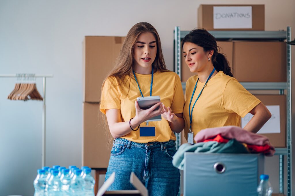 Couple of female volunteers working in community charity donation center
