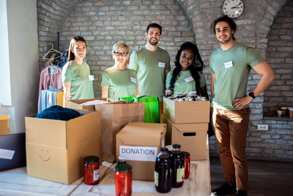Portrait of volunteers with working in community charity donation center.